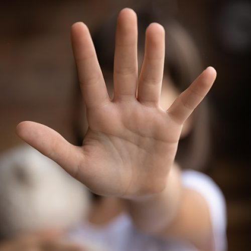 Crop close up of little girl child stretch hand show no gesture protest against domestic violence. Small teen child stand against discrimination or school abuse. Childhood problem, voice concept.